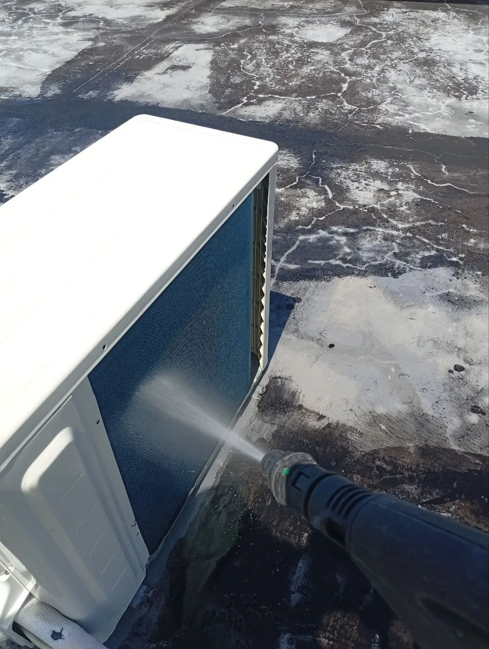 Pressure washing an outdoor AC condenser on a real Mr Cooler job in Bali